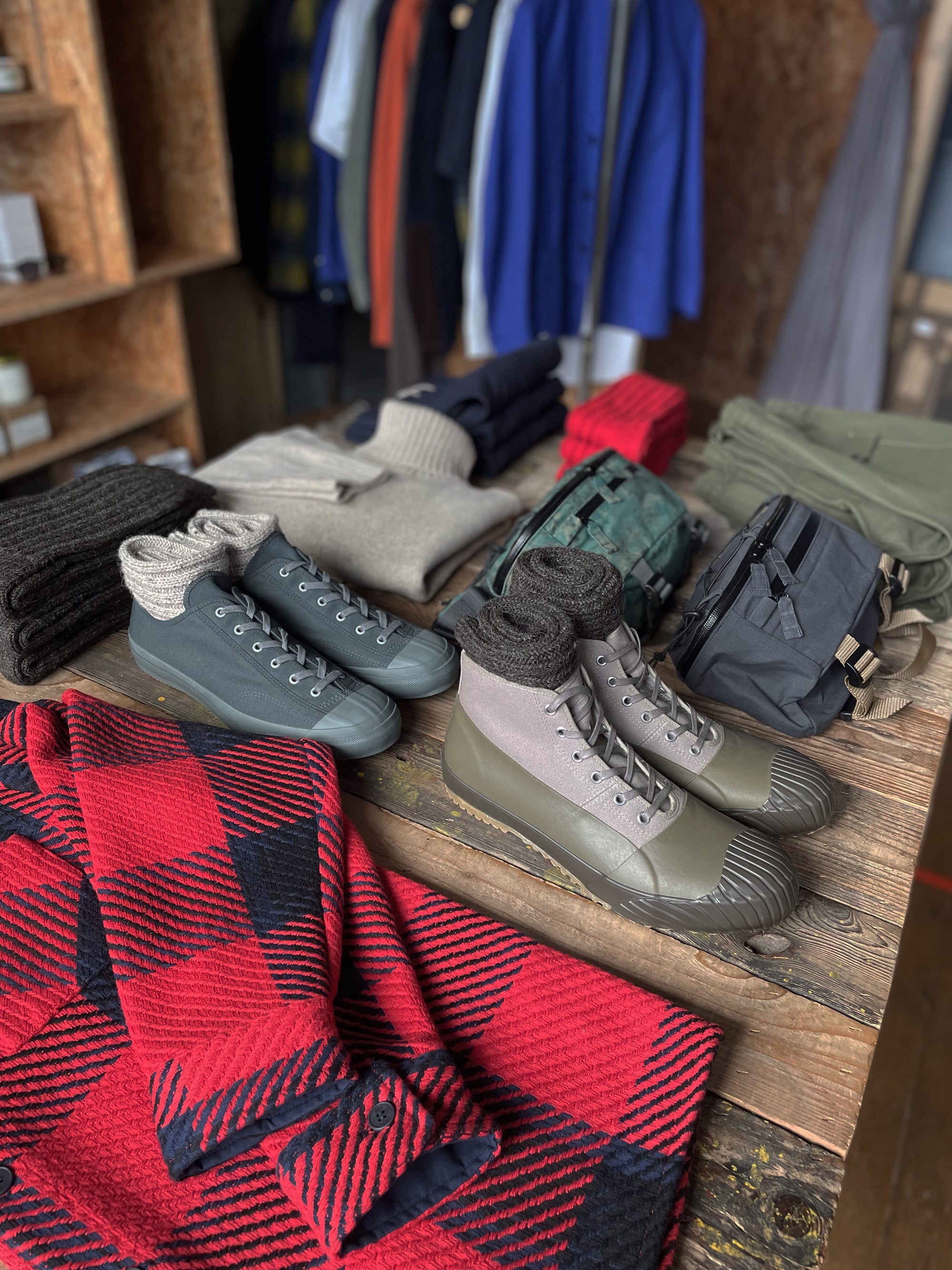 Moonstar Boots and a red plaid jacket are carefully displayed on the table in Assembly